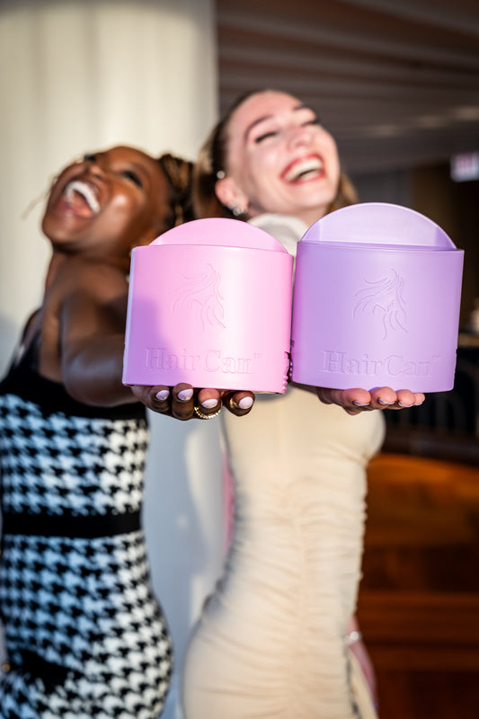 Two people holding pink and purple containers with a blurred background 6